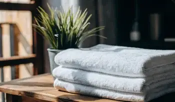 Fresh, clean white towels folded on a wooden table.