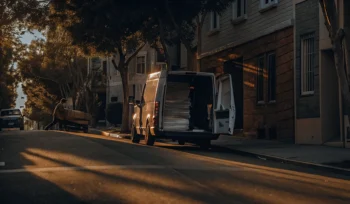 Laundry delivery van on a residential street in Albertson with a worker loading laundry bags.