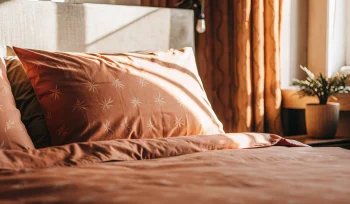 A clean, fluffy comforter on a bed after professional cleaning in East Williston.