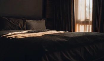 A cozy bed with a clean white comforter after a professional cleaning service in Dix Hills.