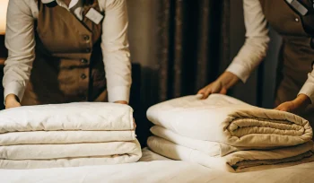 A crisp, clean comforter being folded by a professional cleaning service in Roosevelt Field.