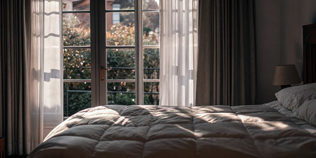 A bright, clean comforter after professional cleaning in a Garden City bedroom.