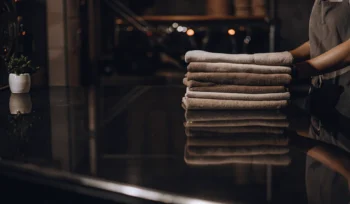 Stack of clean, folded towels from a professional towel laundry service in Commack.