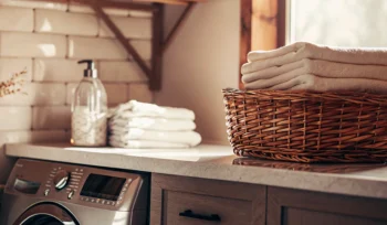 A clean, folded comforter in a basket after professional cleaning in Plandome.