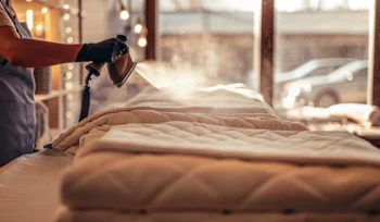 A professional in Roslyn steam cleaning an oversized comforter with specialized equipment.