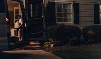 Laundry delivery service driver carrying fresh laundry to a home in Commack.
