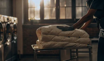 Freshly cleaned and sanitized comforters on a laundry cart from a professional cleaning service in Jericho.