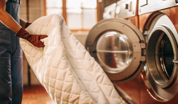 Professional comforter cleaning in Mineola using a commercial-grade washing machine.