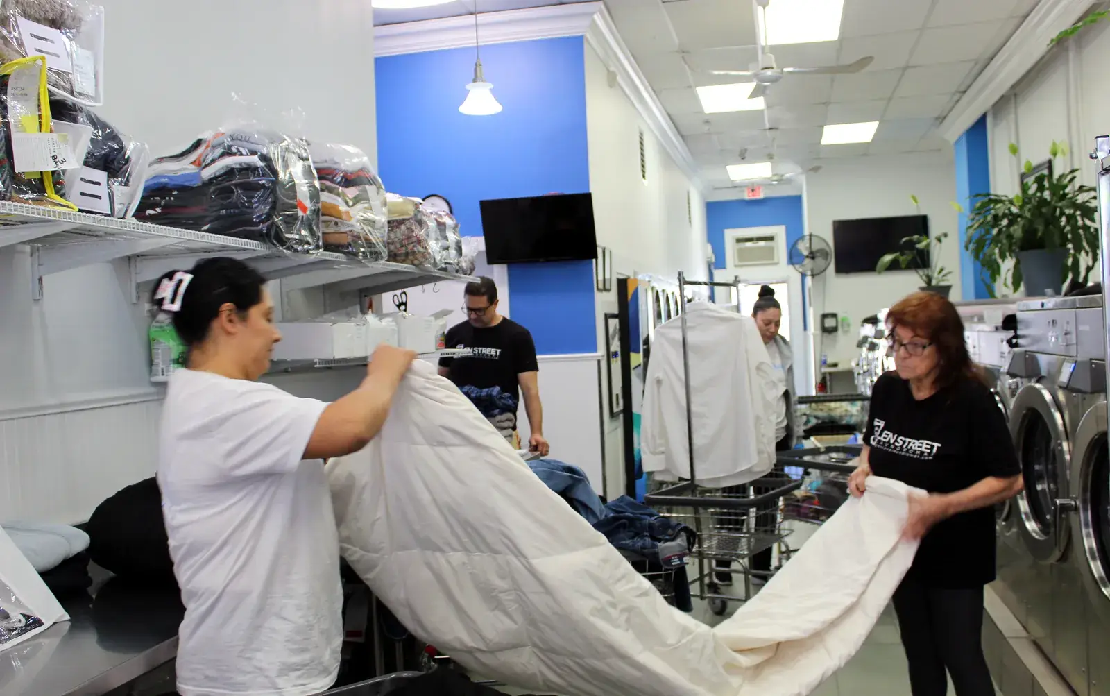 Long Island Laundry Company team folding a large white linen at our Glen Cove facility